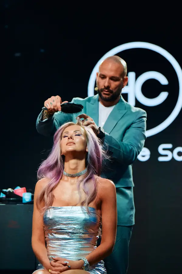 Pokaz mody Wella – stylista współpracujący z agencją wizażystek podczas tworzenia efektownej fryzury.